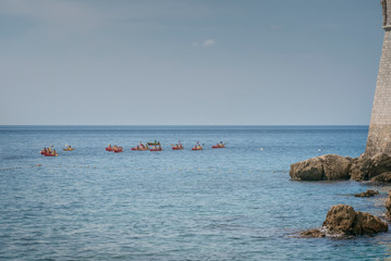Young people are floating in a sea kayaks. Water-based activities in Dubrovnik Bay. Active sea recreation
