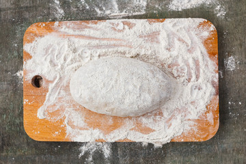 Dough in flour for rye bread on a wooden board