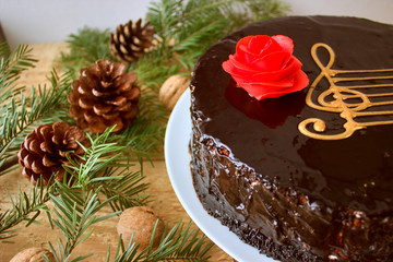 Top View Of A Chocolate Cake With A Stylized Image Of A Musical Staff (Stave) With A G-Clef And A Red Rose On A Wooden Background