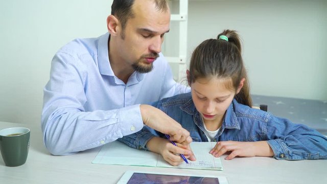 father helping his daughter to do homework