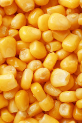 Golden canned corn, as distributed on a plane background and texture of popcorn. Before watching a movie top view. Close-up