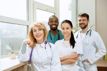 Healthcare people group. Professional male and female doctors posing at hospital office or clinic. Medical technology research institute and doctor staff service concept. Happy smiling models.