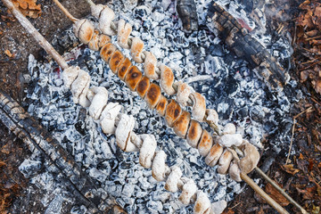 Cooking dough on skewers on a fire