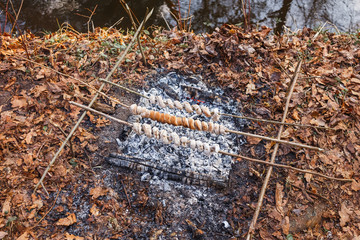 Making dough on skewers on a fire in the spring forest