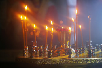Burning candles in front of the altar in the church.