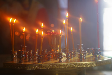 Burning candles in front of the altar in the church.