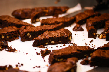 The girl's chef slicks the brownies. Delicious cakes. Brownies with chocolate and nuts.