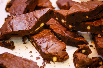The girl's chef slicks the brownies. Delicious cakes. Brownies with chocolate and nuts.