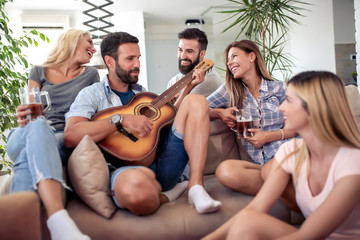 Group of friends have fun with guitar