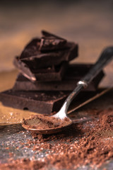 chocolate stack and cocoa powder in a teaspoon. Selective focus