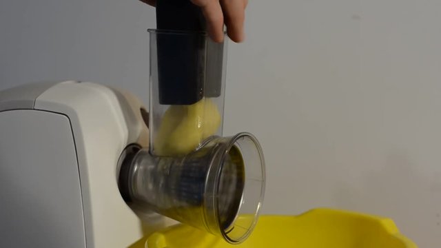 Electric grater cuts raw potatoes