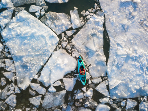 Aerial view of kayaker navigating ice of winter Ontario lake
