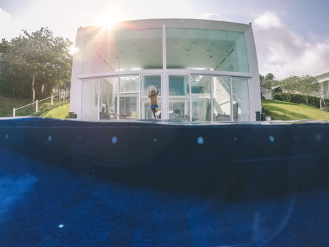Split shot of boy jumping into a deep pool at a luxurious villa