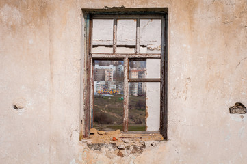 The ruins of an old earthen house without a roof. Holes in the wall at the site of windows and doors