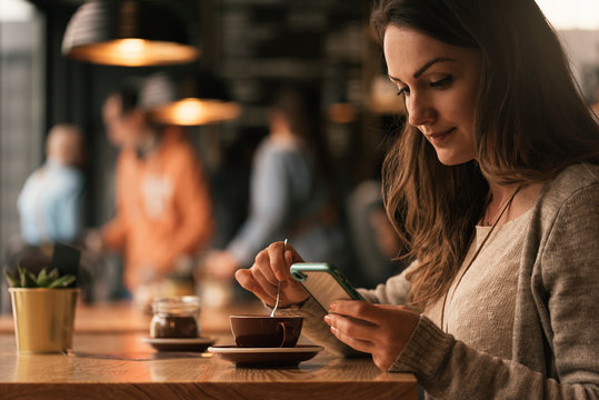 Beautiful woman using mobile into coffee shop.