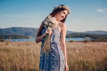 Obraz premium Beautiful woman enjoying field, pretty girl with long dark hair relaxing outdoor