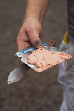 Middle aged man prepping wood will filler prior to painting