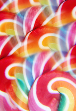 Close-up of swirly rainbow lollipop through prism filter