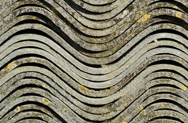 Corrugated slate lies in a pile, side view background texture of slate.