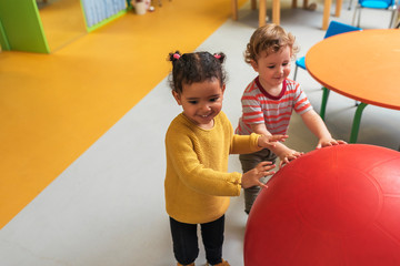 Adorable babies playing together in the kindergarten