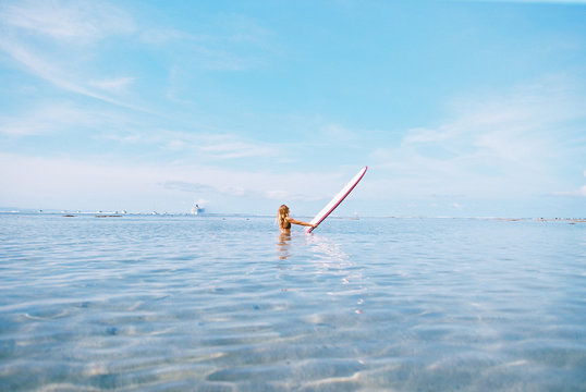 Maui surfer girl in blue ocean
