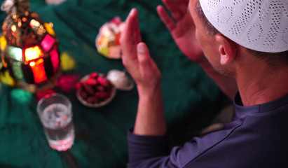 Muslim man in the Holy month of Ramadan. Dua (prayer) for breaking fast and beginning fast. Food and water. Praying, Islam, Religion © Fevziie