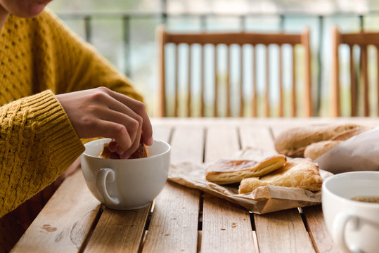 close up view of young woman disking her pastry in her coffee