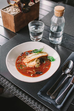 Gazpacho with toasted white bread served at stylish dark table