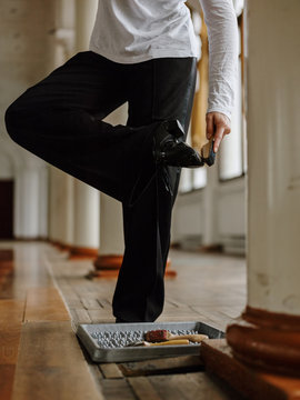 Crop dancer cleaning shoes