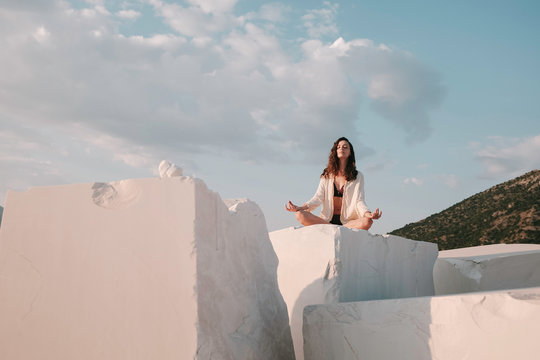 Woman doing yoga on marble blocks