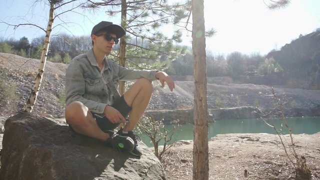 traveler, blogger sitting on a stone