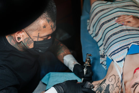 Professional asian tattooer makes a tattoo. Tattoo concept