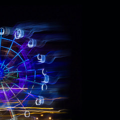 Amusement Park at night - Ferris wheel neon glow in motion with place under text