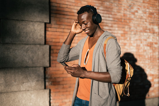 Portrait of young african american man listening music in the street