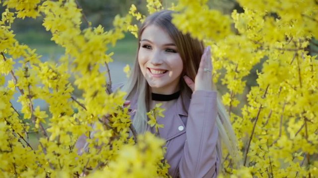 Spring time and happy girl on the landscape of yellow flowers