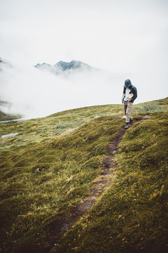 Man Walking in front of Foggy Mountains With Jacket
