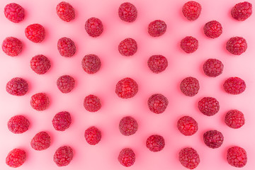 Pattern made from fresh raspberries, top view, flat lay pattern, isolated on a light pink background.