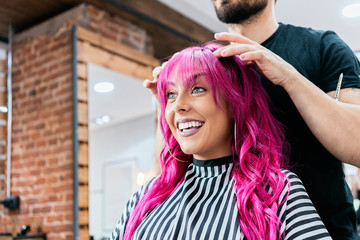Beautiful woman getting haircut by hairdresser in the beauty salon