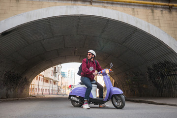 Young stylish male with colorful motor scooter	