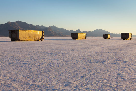 Large trash and recycling containers on playa at dusk, Bonneville Salt Flats, Utah