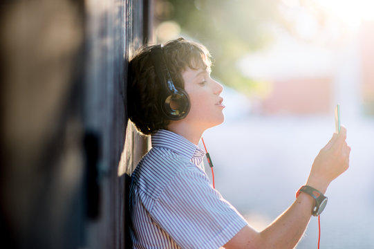 Boy with headphones listening to a music device