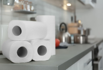 Rolls of paper towels on table in kitchen, space for text