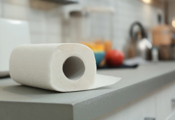 Roll of paper towels on table in kitchen, space for text