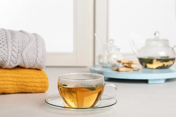 Cup of fresh tea on windowsill indoors. Winter drink