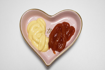 ketch up and honey mustard placed in heart shaped plate isolated in white background