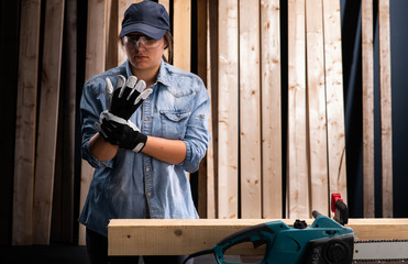 Young woman  using modern electric  saw in the workshop