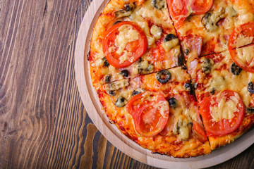 Tasty pizza on a wood background. Top view of hot pizza. Flat lay. Banner