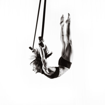 A strong female gymnast on straps.