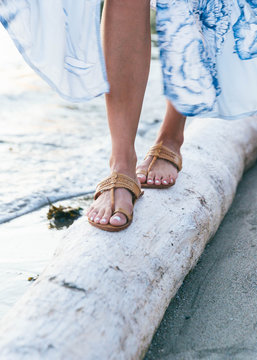 Close up shots of girl wearing sandals by the beach at dusk