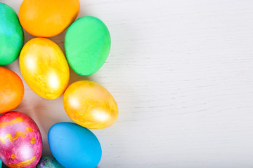 Easter eggs on white wooden background. Top view with copy space, flat lay.